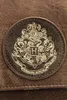 A close-up of a brown shoulder bag with the Hogwarts crest in gold. Anteprima dell’immagine prodotto