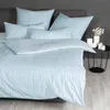 A neatly made bed with striped bedding. Produktbild-Vorschau