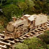 A wooden model train on a miniature railway track surrounded by moss and greenery. Podgląd zdjęcia produktu