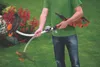 A person holding a Black & Decker electric trimmer in a garden setting. Náhľad obrázku produktu