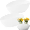 Two white oval-shaped planters are shown against a white background. One planter is empty, and the other contains yellow flowers. Podgląd zdjęcia produktu