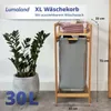 A laundry basket with a plant and some towels on top, with dimensions indicated. Produktbild-Vorschau