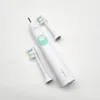 A white electric toothbrush with two replacement brush heads on a white background. Produktbild-Vorschau