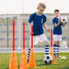 Two young boys are practicing soccer drills on a grassy field with cones and poles. Náhled obrázku produktu