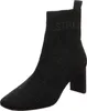 A black knitted boot with stone embellishments and a block heel, shown against a white background. Produktbild-Vorschau