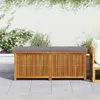 An outdoor wooden storage bench with a gray cushion sits on a patio next to a wall covered in ivy. Náhled obrázku produktu