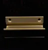 A close-up, studio shot of a single brass door handle against a black background. Produktbild-Vorschau