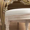 A close-up view of the ornate leg and seat of a chair. Náhled obrázku produktu
