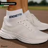 A person wearing white socks and white sneakers on a running track. Produktbild-Vorschau