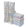 A stack of folded blankets with a larger blanket draped over a stand, all featuring space-themed patterns. Náhled obrázku produktu