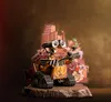 A Wall-E figurine is displayed on a rocky base, with a backdrop of debris and stylized buildings. Anteprima dell’immagine prodotto