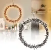 Two illuminated wreaths are displayed, one in the foreground and one in the background, with decorative items on a shelf below. Produktbild-Vorschau