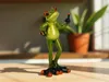 A figurine of a green frog standing on a wooden surface, with a potted plant in the background. Produktbild-Vorschau