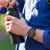A person holding a water bottle and wearing a watch. Voir les images du produit