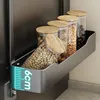 A kitchen shelf with jars of food items attached to a refrigerator. Anteprima dell’immagine prodotto