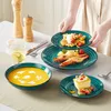 A table setting with plates of food and soup, with a person placing a plate. Produktbild-Vorschau