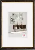 A framed picture of a wall with several framed botanical prints above a wooden cabinet. Produktbild-Vorschau