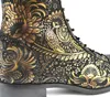 A close-up view of a black boot with an intricate gold floral pattern. Produktbild-Vorschau