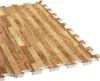 A close-up, angled view of interlocking foam floor mats with a wood-grain pattern. Náhľad obrázku produktu