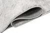 A close-up view of a rolled-up rug, showing the texture and underside. Voir les images du produit