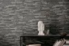 A shelf with decorative items in front of a stone-patterned wallpaper. Náhľad obrázku produktu