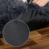 A close-up view of the bottom of a dark gray, plush dog bed, showing its anti-slip nubs on a wooden floor. Anteprima dell’immagine prodotto
