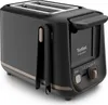 A black toaster with gold accents is shown from a slight angle against a white background. Voir les images du produit