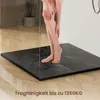 A person's legs are shown standing in a shower on a black shower tray with water running. Anteprima dell’immagine prodotto