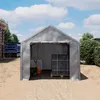 A gray tent garage with construction materials inside and a truck in the background. Produktbild-Vorschau