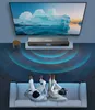 A couple relaxing on a couch, watching TV, with a soundbar placed below the TV. Voir les images du produit