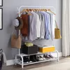 A white metal garment rack with clothes, hats, bags, and shoes on display. Produktbild-Vorschau