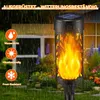 A solar-powered flame light is shown in a garden setting during rainfall. Produktbild-Vorschau
