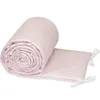 A rolled-up pink crib bumper with a white star pattern, tied with white ribbons. Produktbild-Vorschau