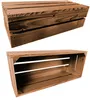 Two wooden crates are shown against a white background. The top crate is viewed from the side, showing its slatted construction. The bottom crate is viewed from a slightly elevated angle, revealing its open interior. Produktbild-Vorschau