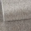 A close-up view of a textured carpet with a folded edge. Produktbild-Vorschau