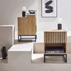 Two wooden bedside tables are displayed on a multi-level white platform. Produktbild-Vorschau