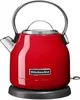 A red KitchenAid electric kettle on its black base, photographed against a white background. Náhled obrázku produktu