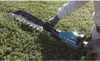 A person is using a hedge trimmer to trim a bush. Anteprima dell’immagine prodotto