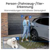 A woman is charging an electric car while a dog lies on the ground nearby. The image is overlaid with text and icons indicating smart detection features. Produktbild-Vorschau