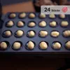 Close-up of a waffle iron with dough balls in each cavity. Náhľad obrázku produktu
