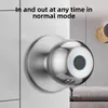 A close-up of a smart door knob with a fingerprint scanner, mounted on a white door. Podgląd zdjęcia produktu
