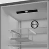 Interior view of a refrigerator showing shelves and cooling technology. Voir les images du produit