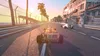 A racing car on a track with palm trees and buildings in the background during sunset. Podgląd zdjęcia produktu