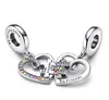 A pair of silver heart-shaped charms with puzzle pieces, adorned with colorful stones, against a white background. Anteprima dell’immagine prodotto