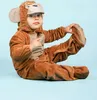 A child wearing a monkey costume sits on a light blue background. Anteprima dell’immagine prodotto