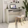 A white desk with a laptop, books, and a small Eiffel Tower replica, next to a gray chair and a large potted plant. Podgląd zdjęcia produktu