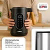 A person holding a black electric kettle with a wooden handle, displaying its digital interface and features. Produktbild-Vorschau