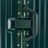 Close-up of a dark green suitcase handle and latch mechanism. Náhľad obrázku produktu