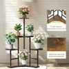 A multi-tiered plant stand with various potted plants displayed against a white brick wall. Náhľad obrázku produktu