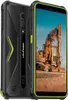A rugged smartphone is shown from a diagonal angle, with its back and front visible. The screen displays a construction excavator. Náhled obrázku produktu